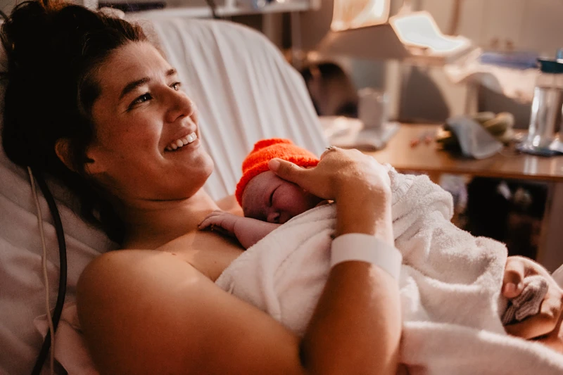 Mother smiling with newborn baby on chest 